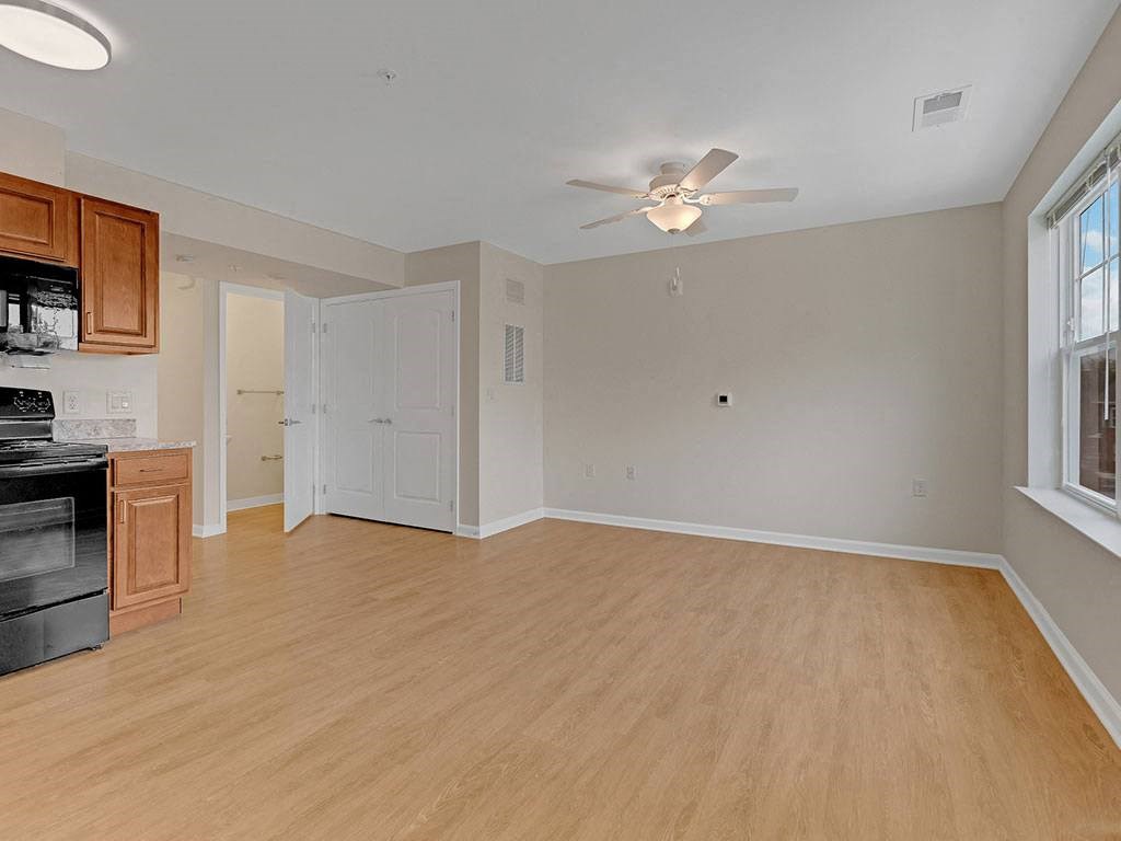 an empty kitchen and living room with a ceiling fan
