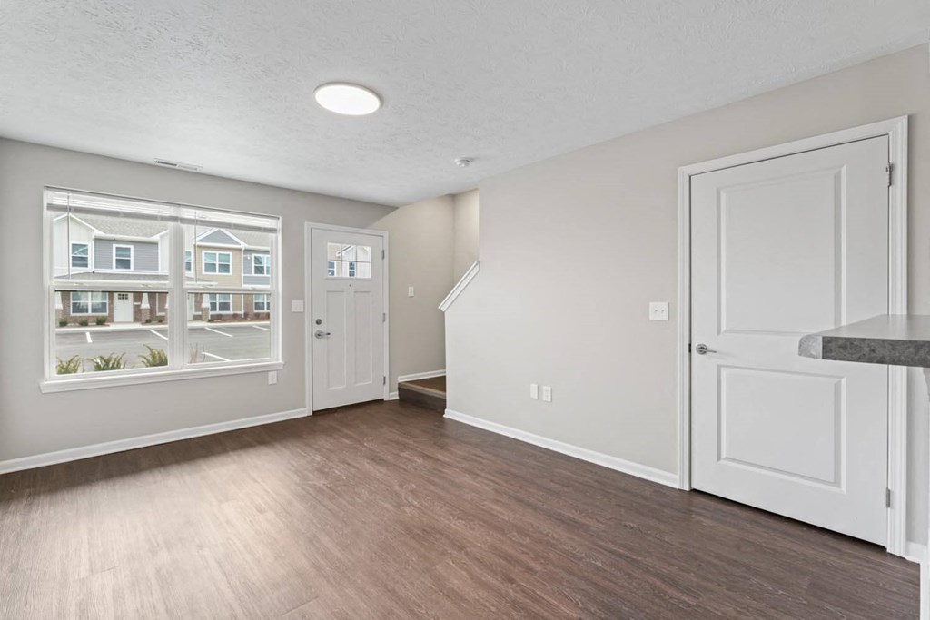 an empty living room with a window and a door