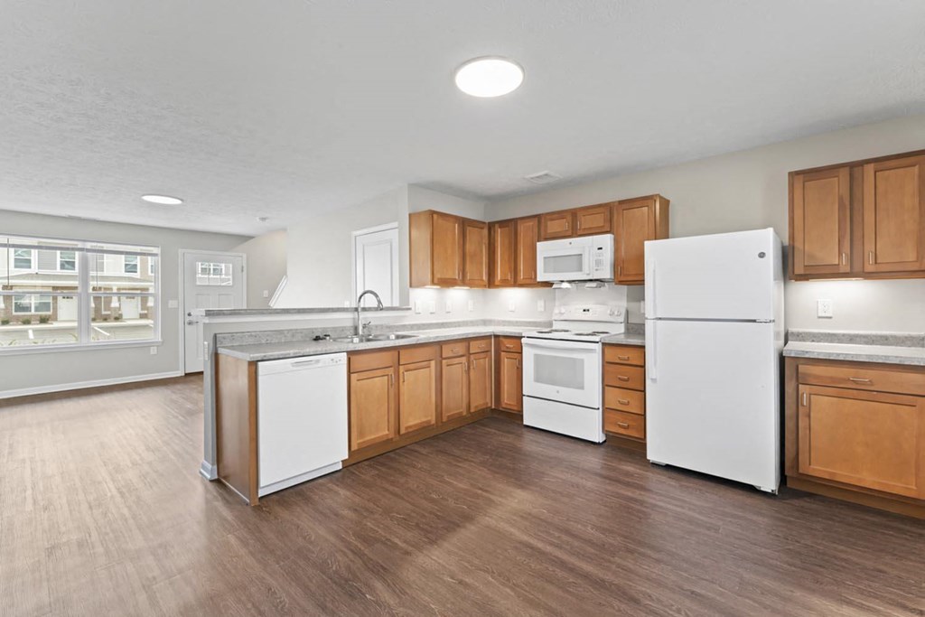 an empty kitchen with wooden cabinets and white appliances