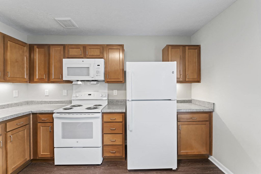 a kitchen with white appliances and wooden cabinets