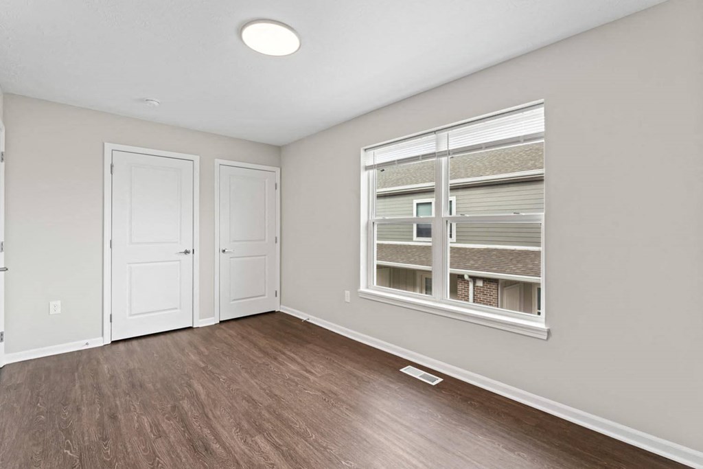 an empty living room with a window and a door
