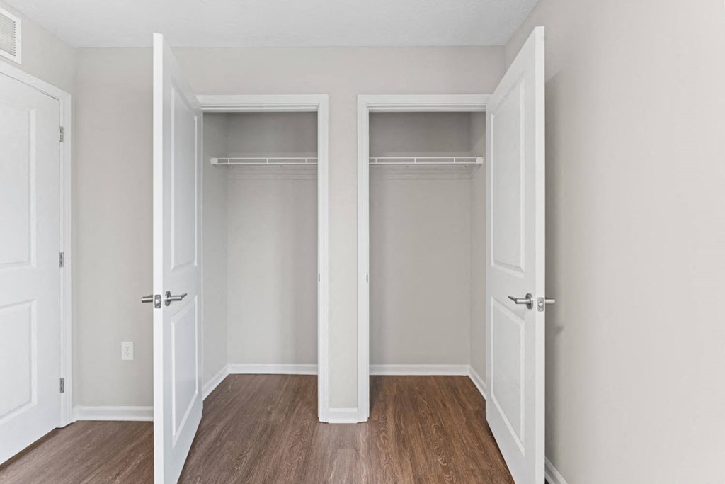 an empty room with two closets and a wood floor