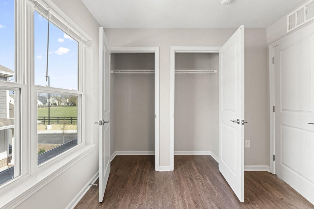 a bedroom with two closets and a window