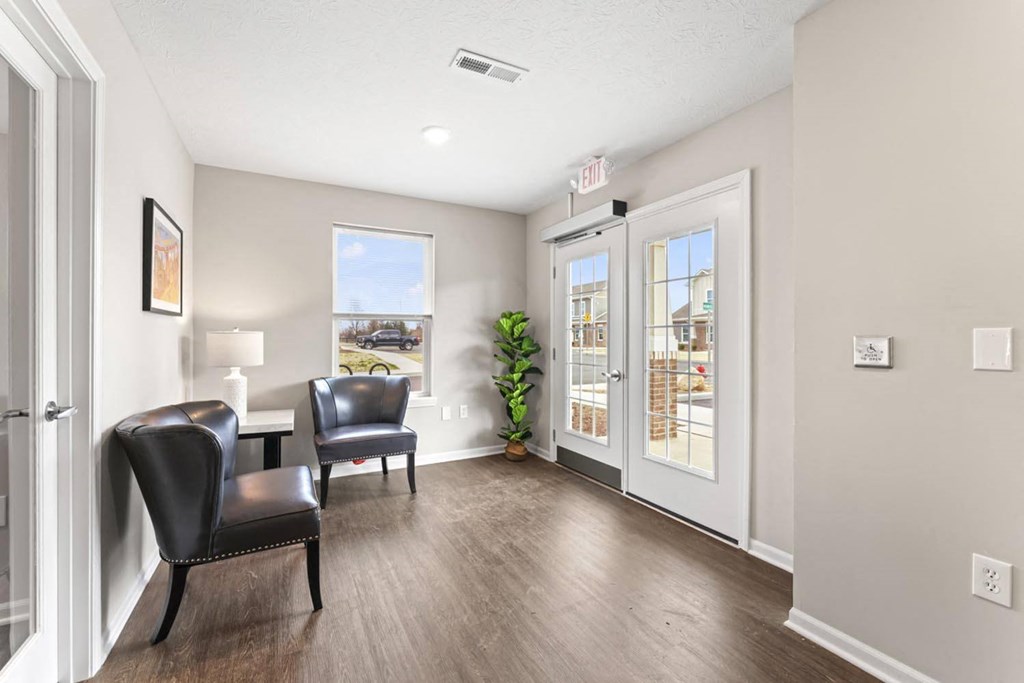a living room with chairs and a door to a patio
