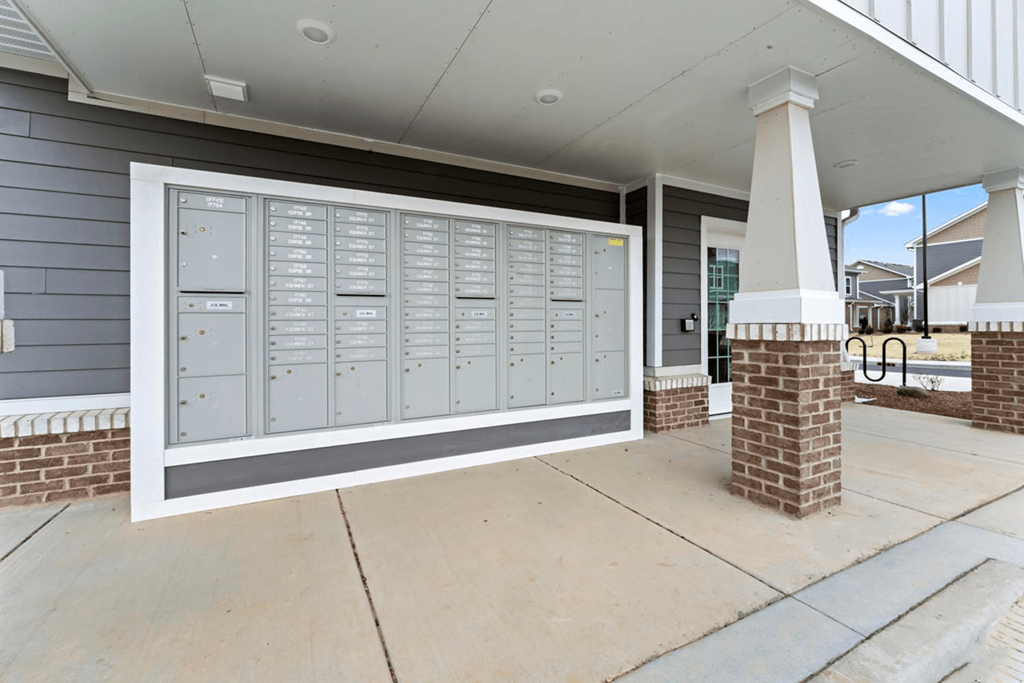 the front porch of a house with mailboxes on the wall