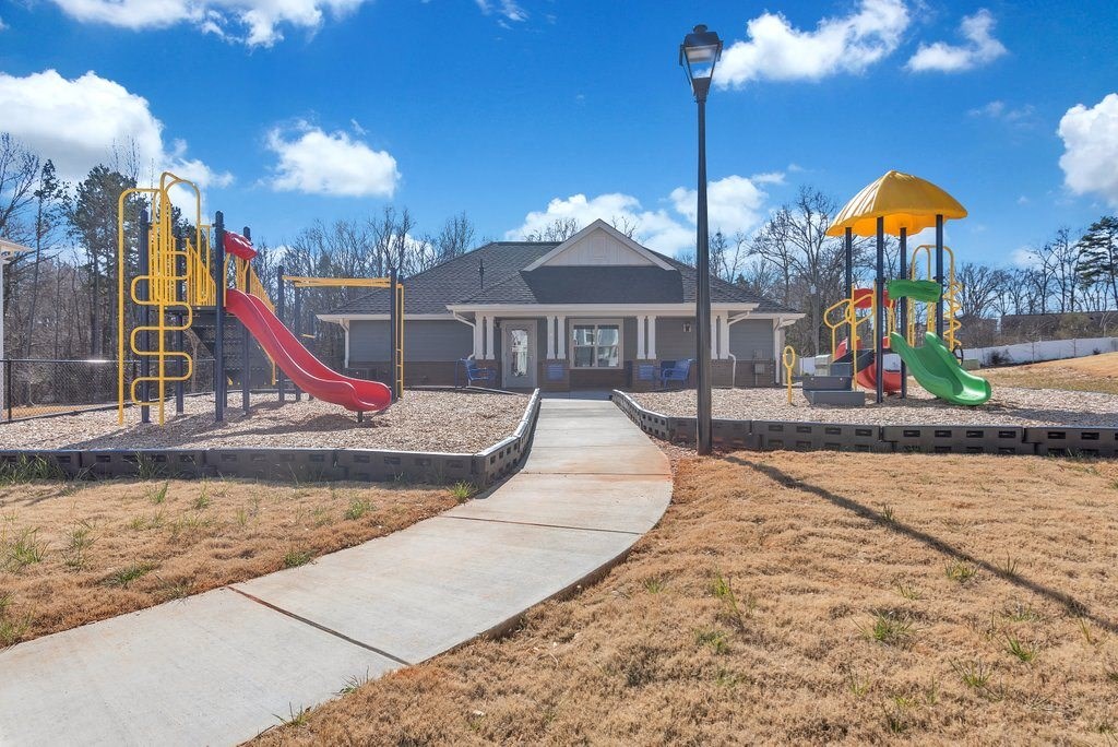 the playground is in front of a house with playground equipment
