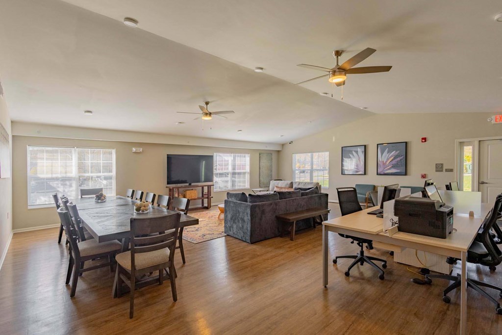 A room with a dining table and a work desk.