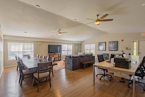 A room with a dining table and a work desk.