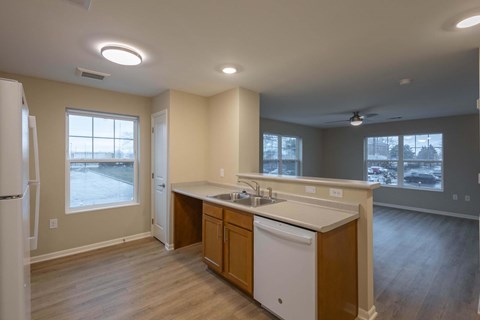 A kitchen with wooden cabinets and a white dishwasher.