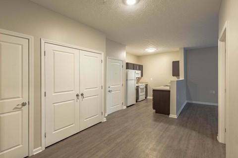A kitchen area with white cabinets and a refrigerator.