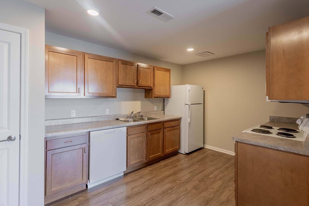 A kitchen with wooden cabinets and a white refrigerator.