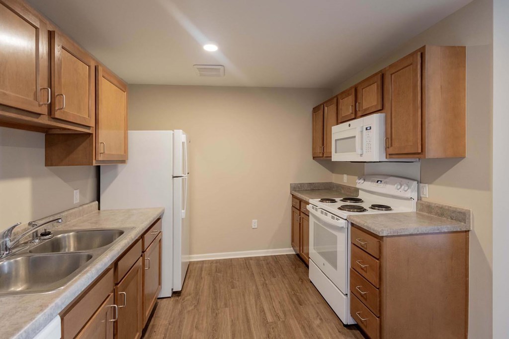 A kitchen with a white refrigerator, white microwave, and white stove.