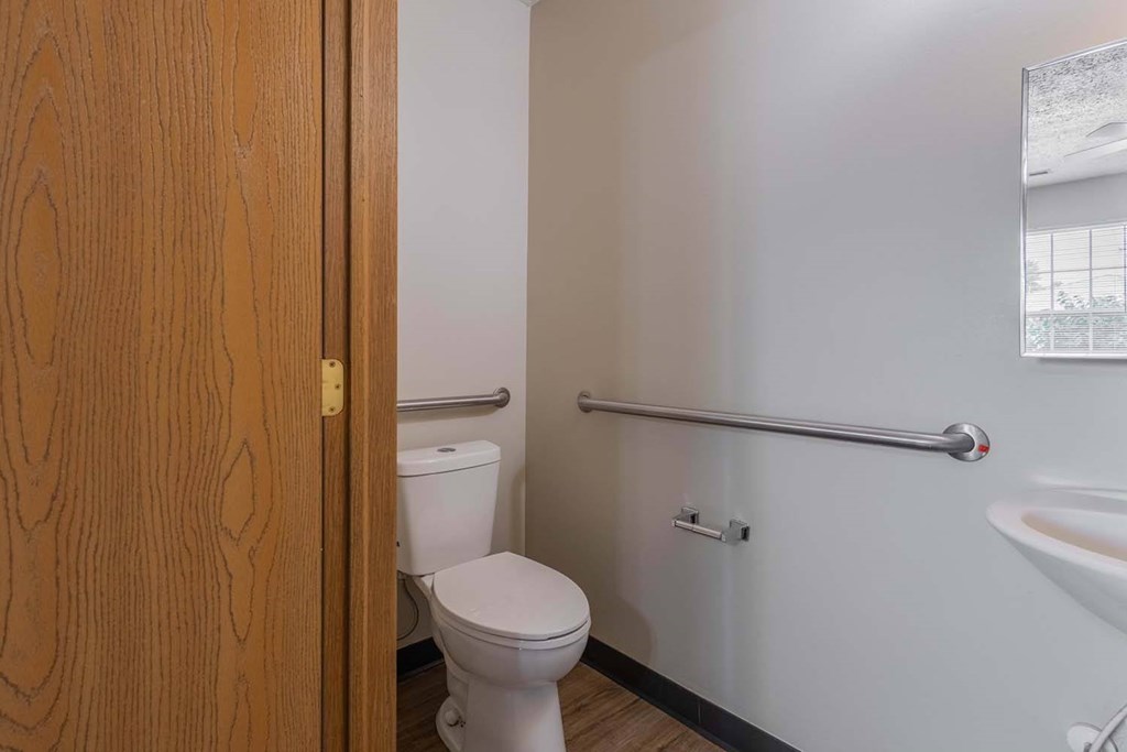 A white toilet sits in a bathroom next to a wooden door.