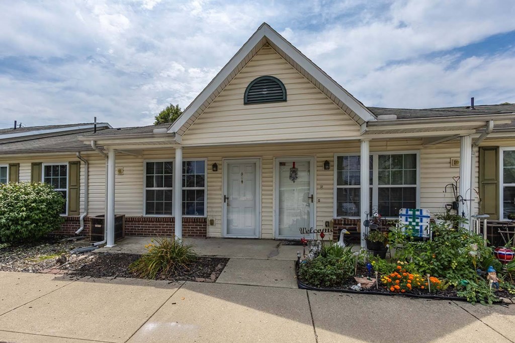 A house with a front yard and a sign in front.