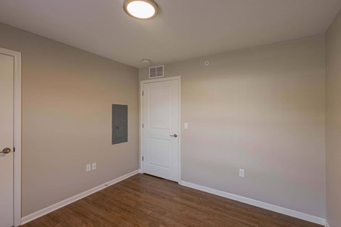 A room with a white door and a light on the ceiling.