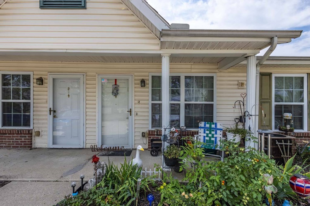 A house with a white door and a porch with a white railing.