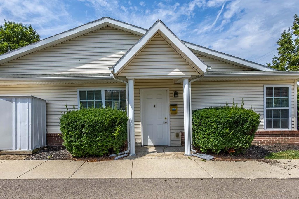A house with a white door and two windows.