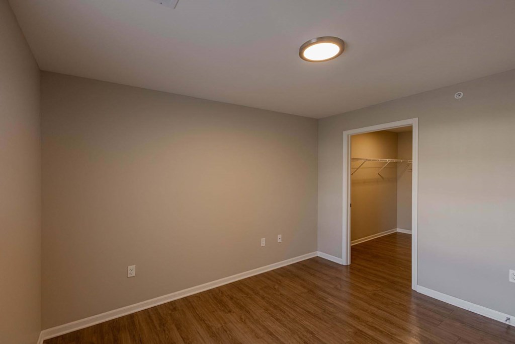 A room with a wooden floor and a white ceiling with a light fixture.