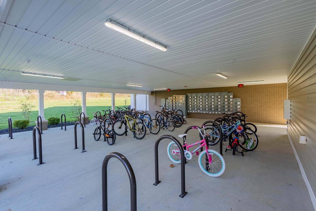 A bicycle parking area with a white ceiling and grey floor.