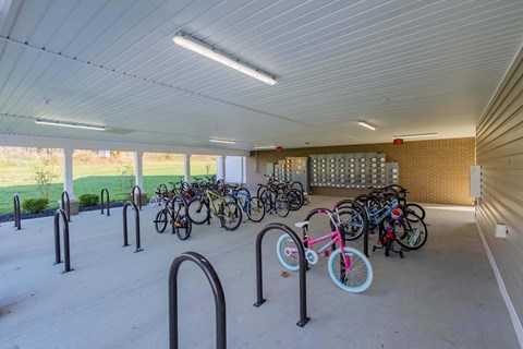 A bicycle parking area with a white ceiling and grey floor.