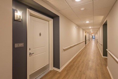 A long hallway with a door on the left and a door on the right.