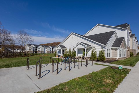 A park with a bike rack and a building in the background.