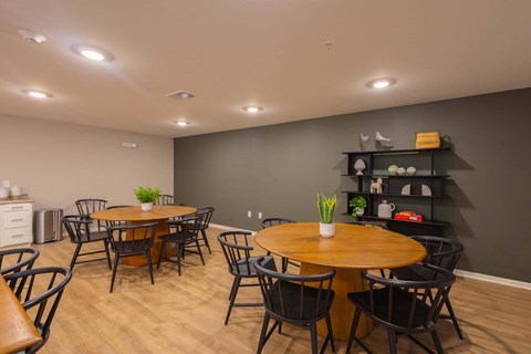 A dining room with a wooden table surrounded by chairs.