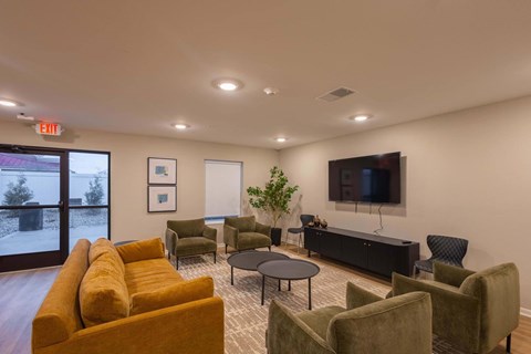 A living room with a yellow couch and a flat screen TV.