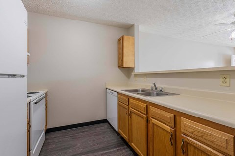 A kitchen with wooden cabinets and a white fridge.