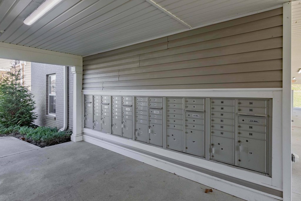 A long row of mailboxes are lined up on the side of a building.
