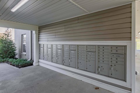 A long row of mailboxes are lined up on the side of a building.