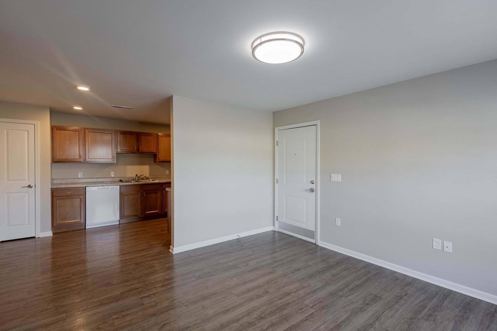 A kitchen with wooden floors and white walls.