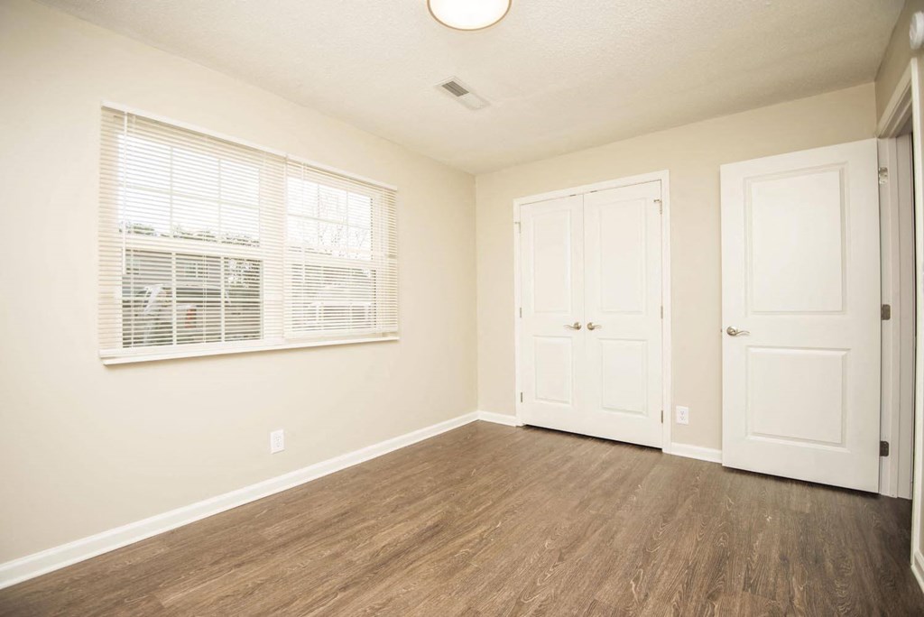 an empty living room with a window and a door