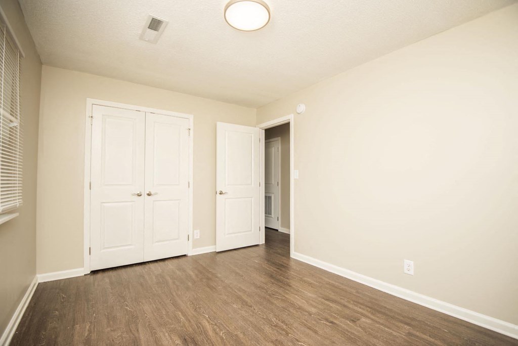 an empty living room with white walls and wood floors