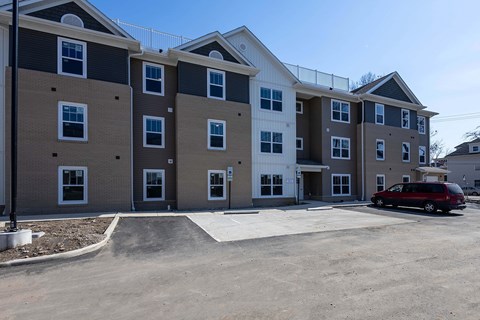 A red car is parked in front of a building.