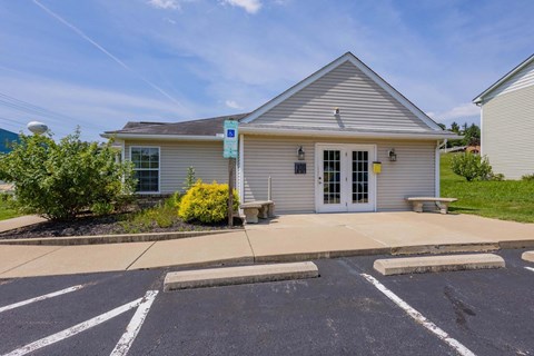 A small building with a parking lot in front.