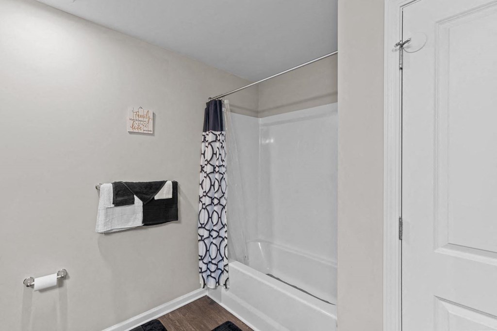 a white bathroom with a shower and a curtain