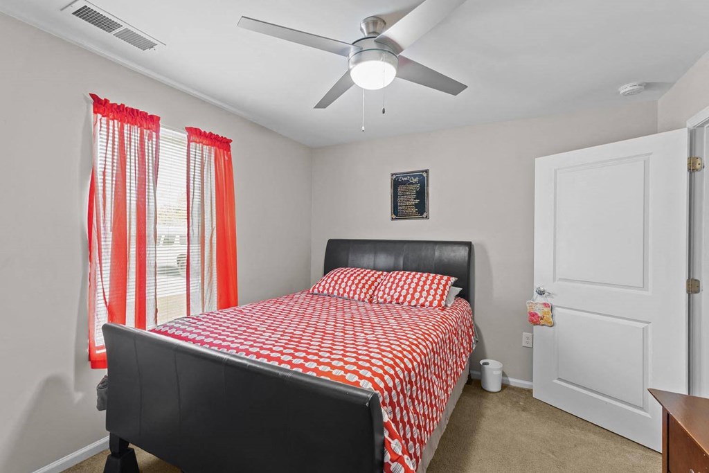 a bedroom with a bed and a ceiling fan
