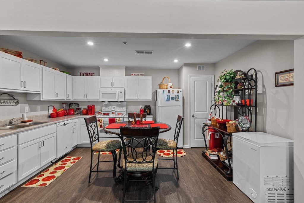 a kitchen with white cabinets and a table and chairs