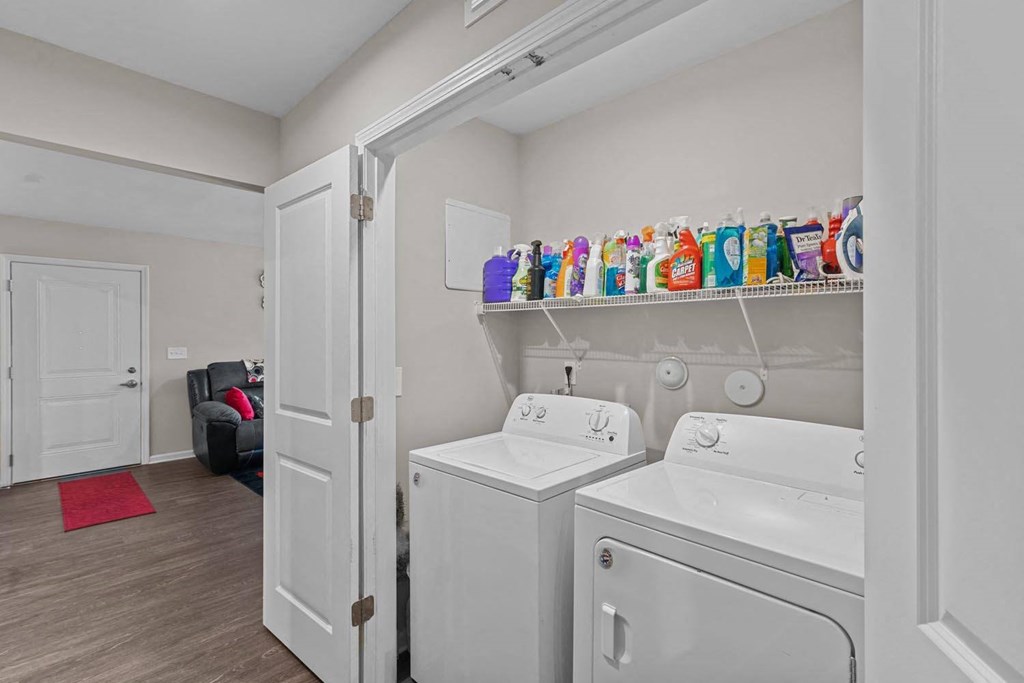a washer and dryer in a room with a door to a living room
