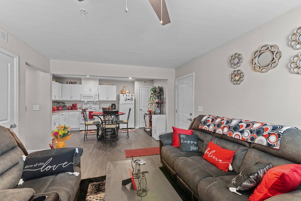 a living room with two couches and a kitchen with a table