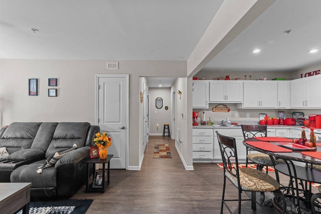 a living room with a couch and a kitchen with a table and chairs