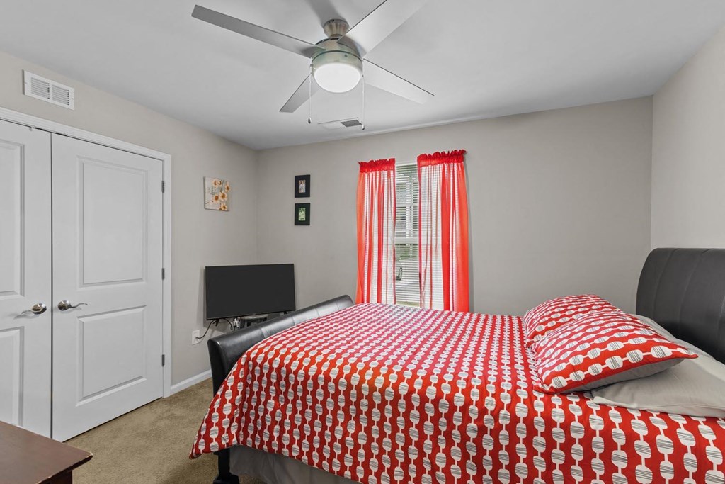 a bedroom with a bed and a ceiling fan