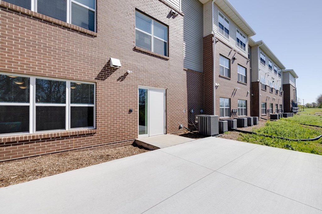 a walkway leading to a brick building with a white door
