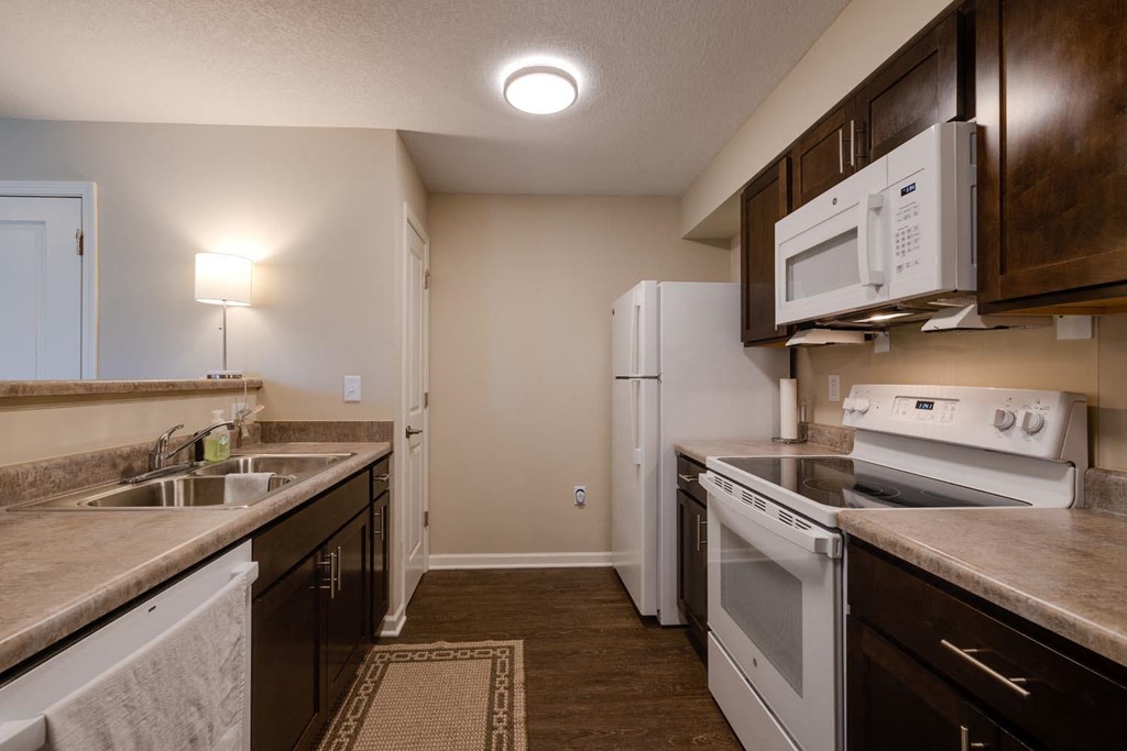 a kitchen with white appliances and brown cabinets