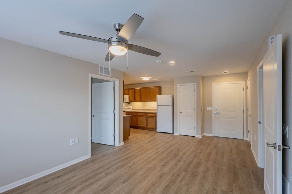 A room with a ceiling fan and wooden flooring.