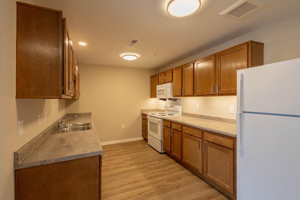 A kitchen with wooden cabinets and a white refrigerator.