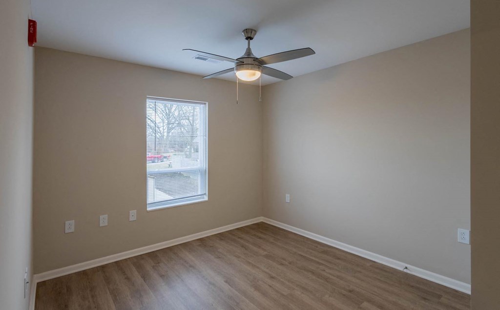 A room with a ceiling fan and a window.