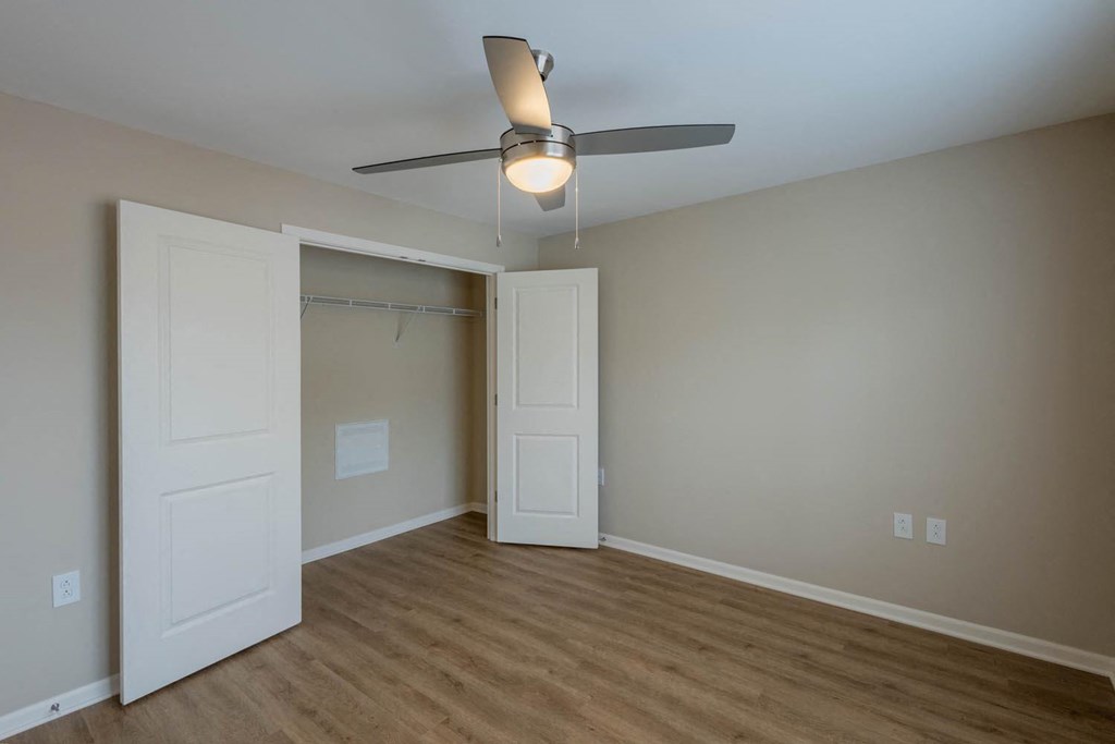 A room with a ceiling fan and two doors.