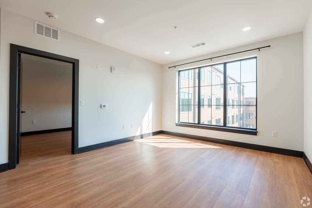 A room with a wooden floor and a large window.